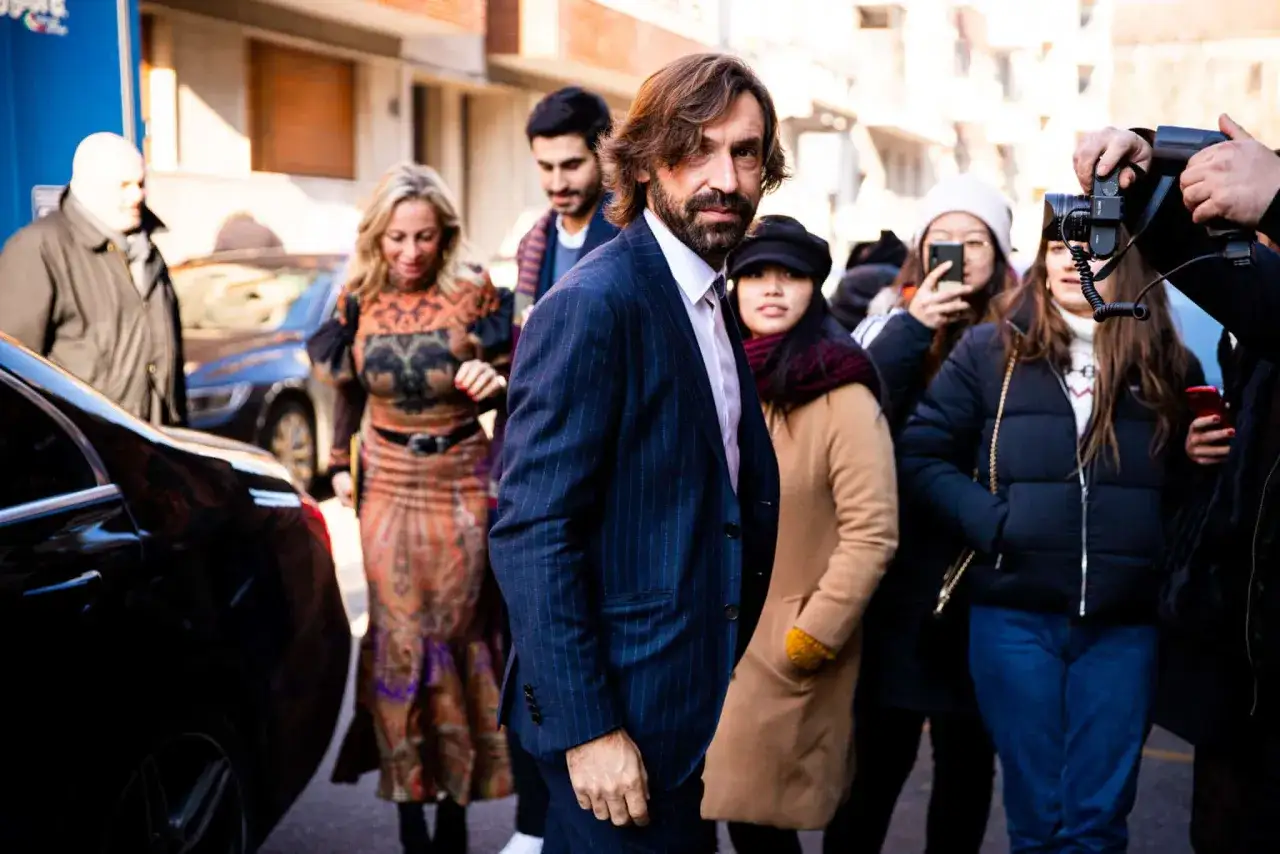 Snygga fotbollsspelare som Andrea Pirlo och hans följe, omgivna av fotografer och fans, på väg till ett event.