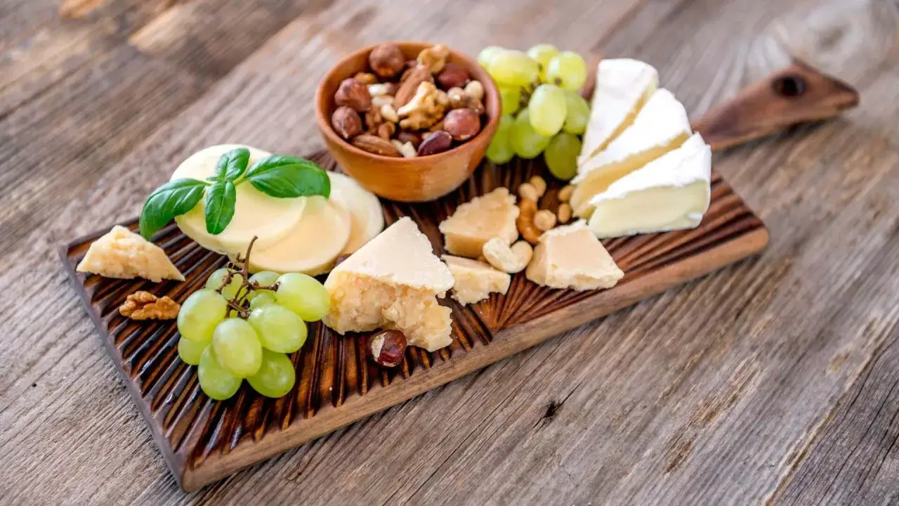 Deska serów z winogronami, orzechami i grana padano, idealna do degustacji.
