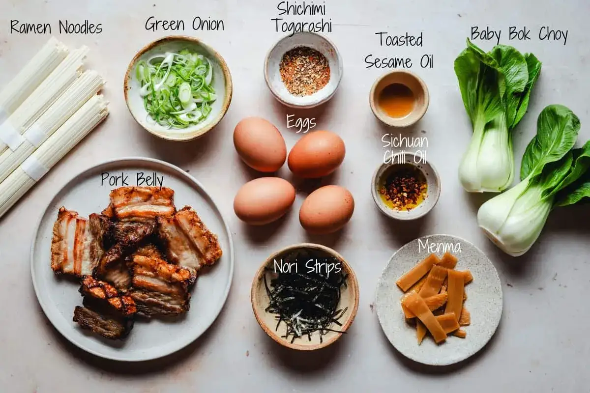 Zutaten für ein authentisches Ramen Rezept original: Nudeln, Schweinebauch, Eier, Frühlingszwiebeln, Bok Choy, Menma, Nori, Shichimi Togarashi, Sesamöl und Chiliöl.