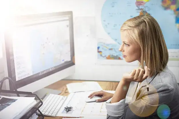 Pracownik biura podr&oacute;ży przy biurku z mapą
