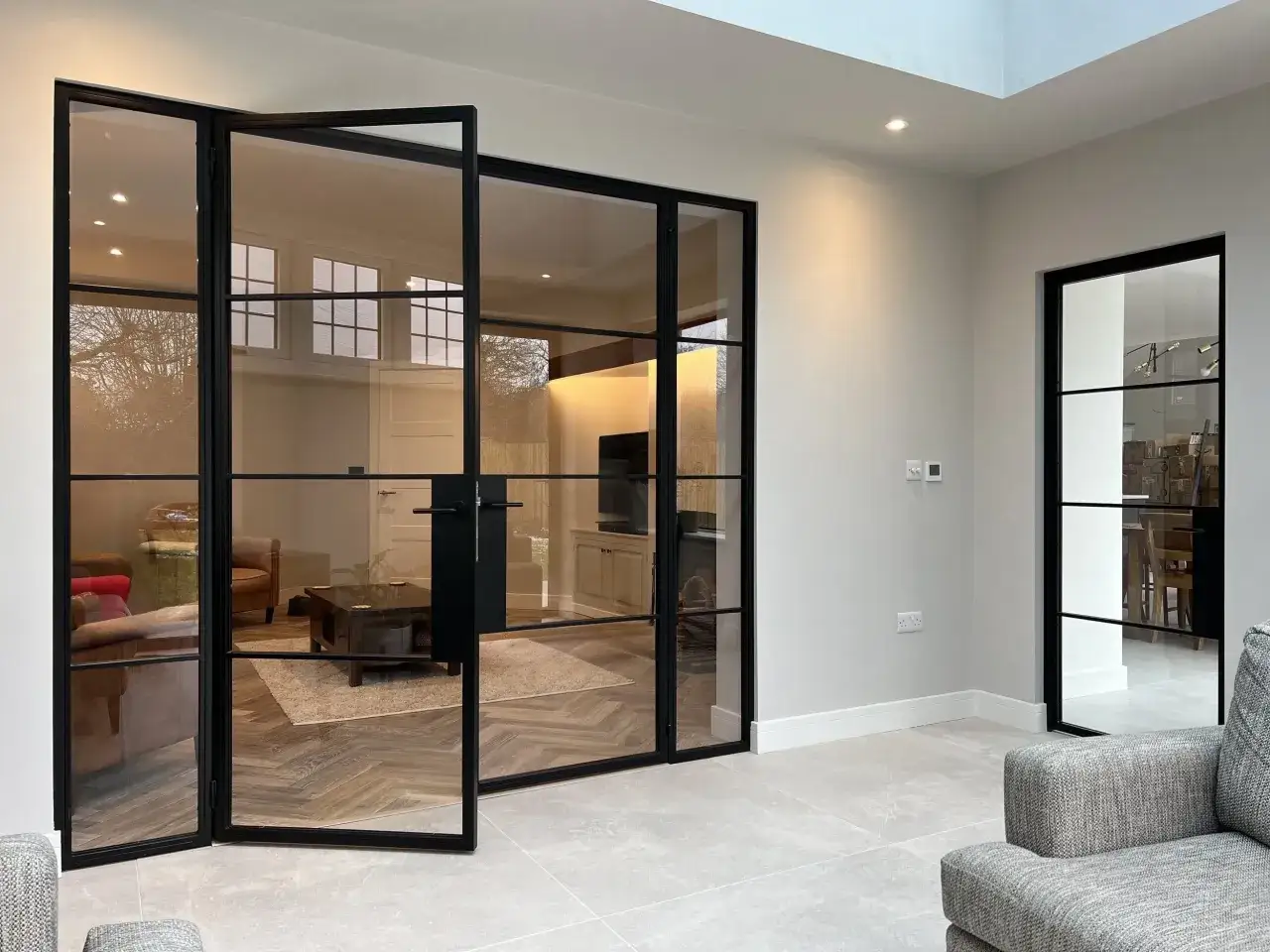 Puertas de interior con marcos negros y paneles de cristal que permiten ver el sal&oacute;n. Diversos tipos de cristales para puertas de interior.