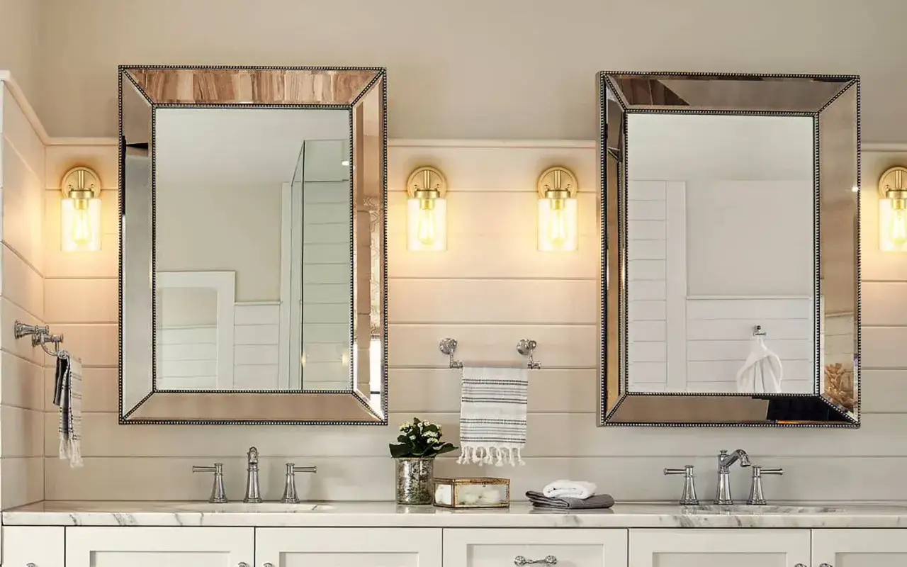 These modern wall sconces with glass shades and Edison bulbs are far from out of style, perfectly complementing the dual vanity and mirrors.