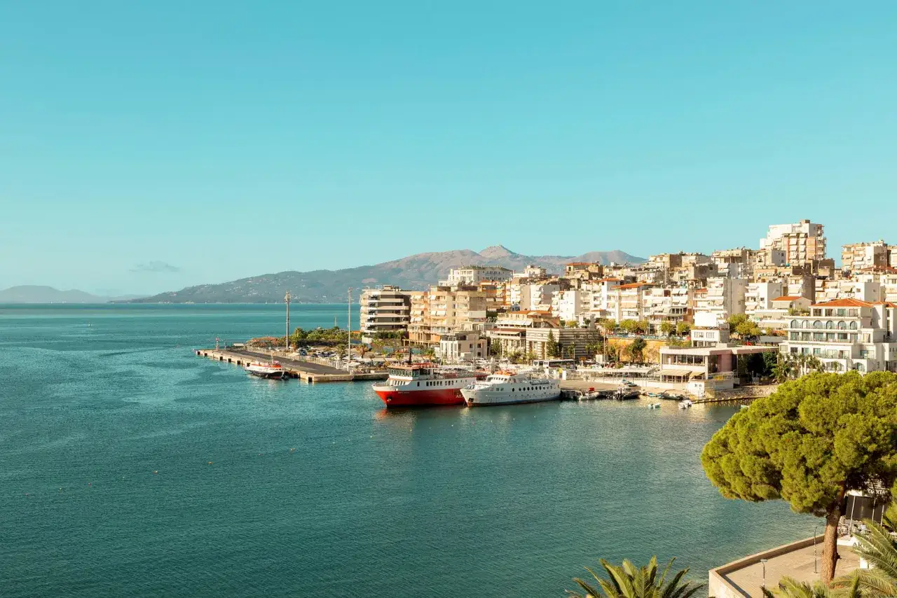 Hamnen i Sarand&euml;, Albanien, med vita och r&ouml;da fartyg vid kajen. Perfekt f&ouml;r dig som s&ouml;ker resa till Albanien tips.