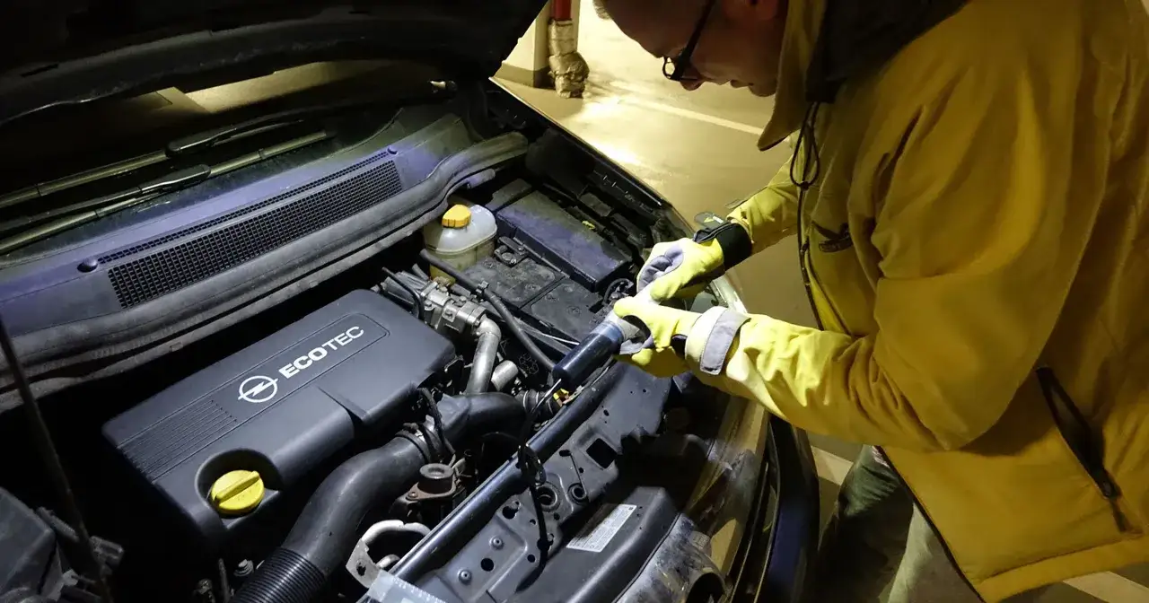Mechanik w żółtej kurtce sprawdza silnik EcoTec, jeden z najlepszych silników benzynowych.