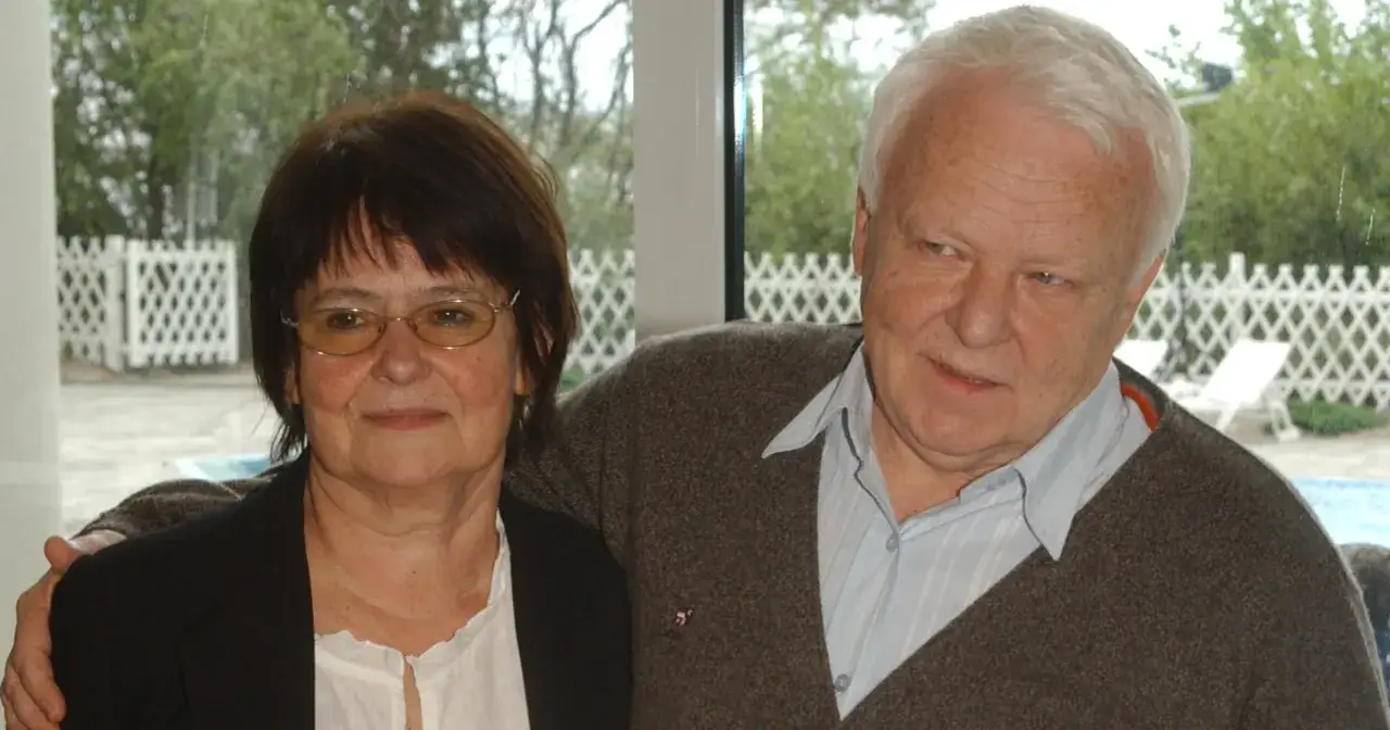 Anna Opani i jej mąż, uśmiechnięci, pozują do zdjęcia na tle ogrodu z basenem.
