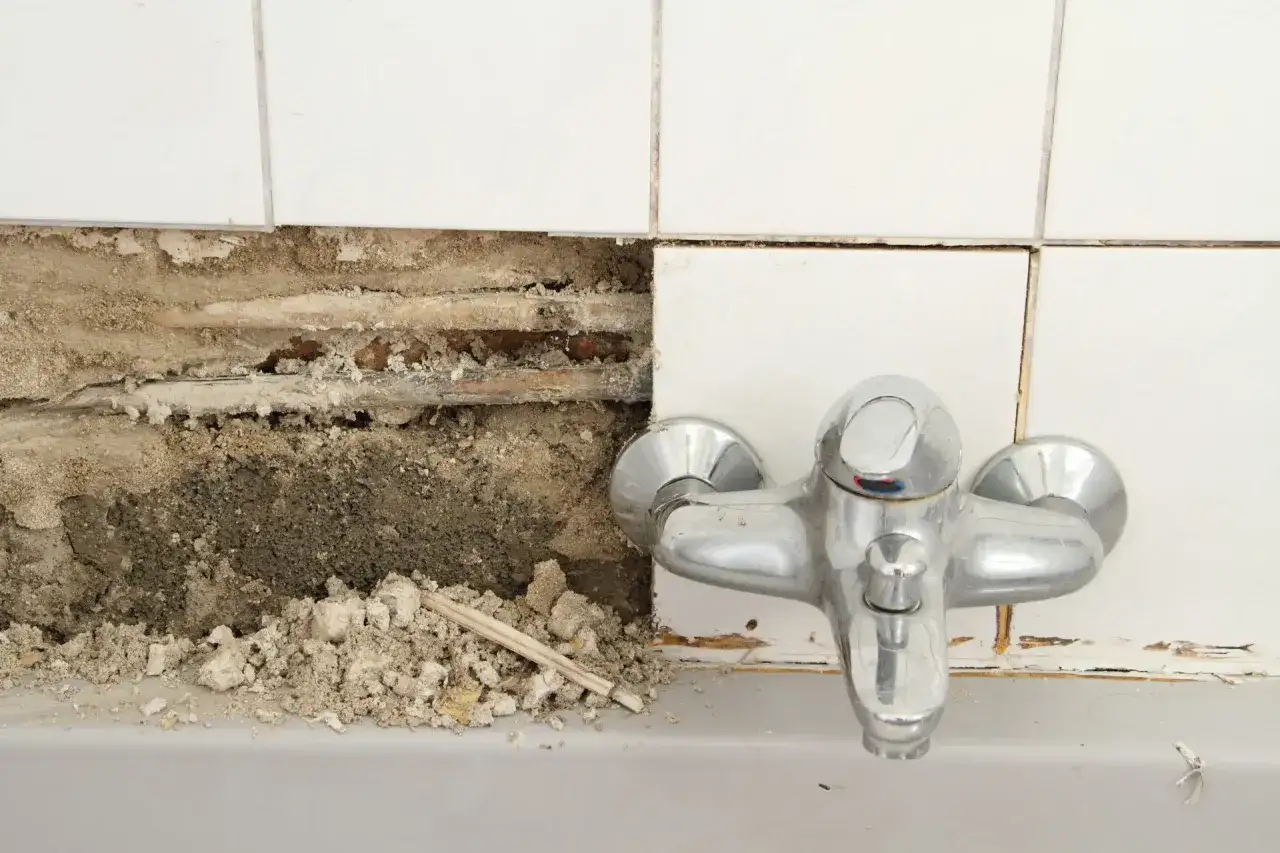 Wasser kommt aus fugen boden, Rohre sind freigelegt, Fliesen sind beschädigt.