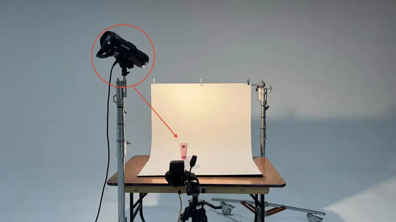 Ustawienie oświetlenia do sesji produktowej. Jaki obiektyw do fotografii produktowej? Pudełko z kremem na stole, oświetlone lampą Profoto.