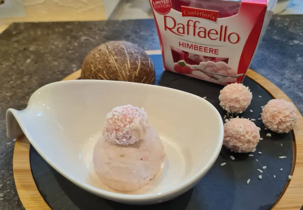 Raffaello Himbeer Eis in einer Schale, daneben Kokosnuss und Pralinen. Ein süßer Genuss!
