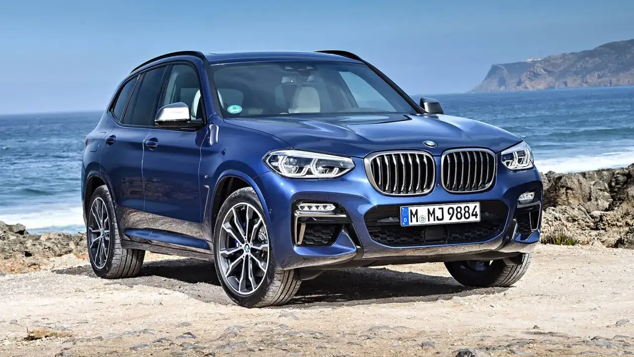 Bl&aring; BMW X3 vid havet. Kanske ett problem med att hitta parkering h&auml;r?