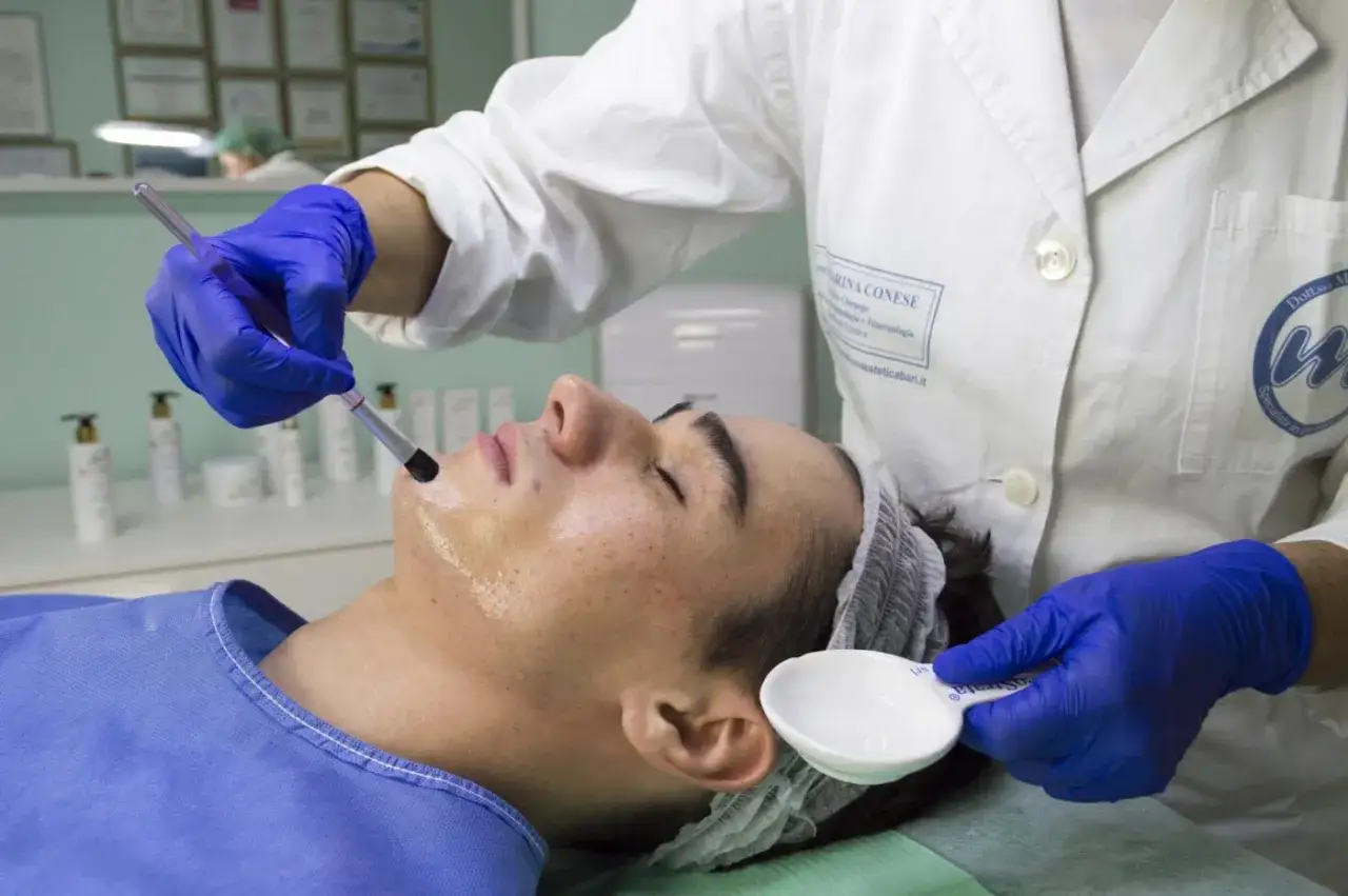 Un professionista applica un trattamento per il peeling viso con un pennello. Scopri cos'è il peeling viso e i suoi benefici.