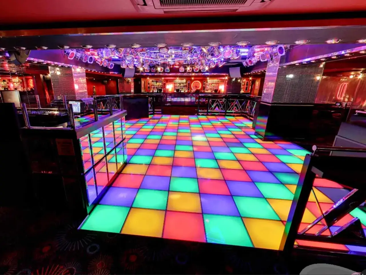 Pista da ballo colorata in un club notturno, pronta per le recensioni dei clienti. Luci stroboscopiche e atmosfera vibrante.