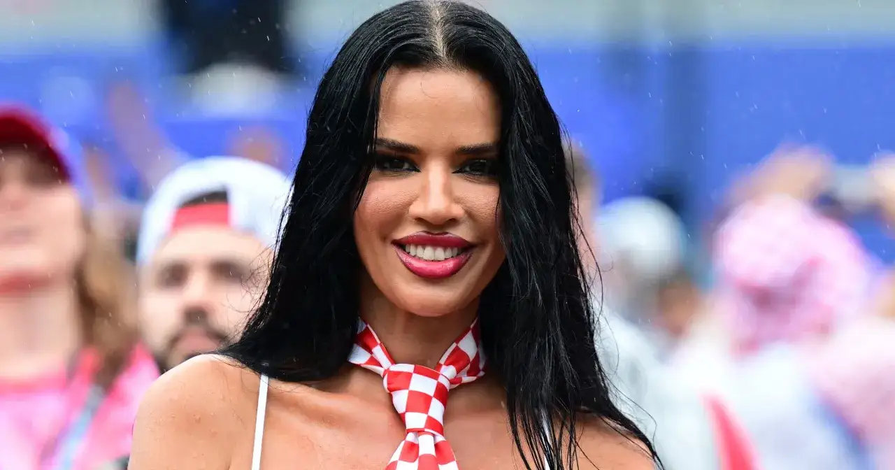 Uśmiechnięta Ivana Knoll, której wiek nie jest widoczny, w czerwono-białą szachownicę. W tle tłum kibiców.