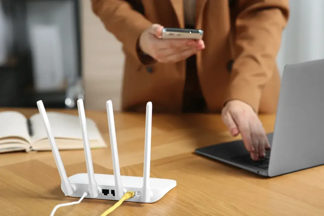 osoba patrząca na router z frustracją lub znakiem zapytania
