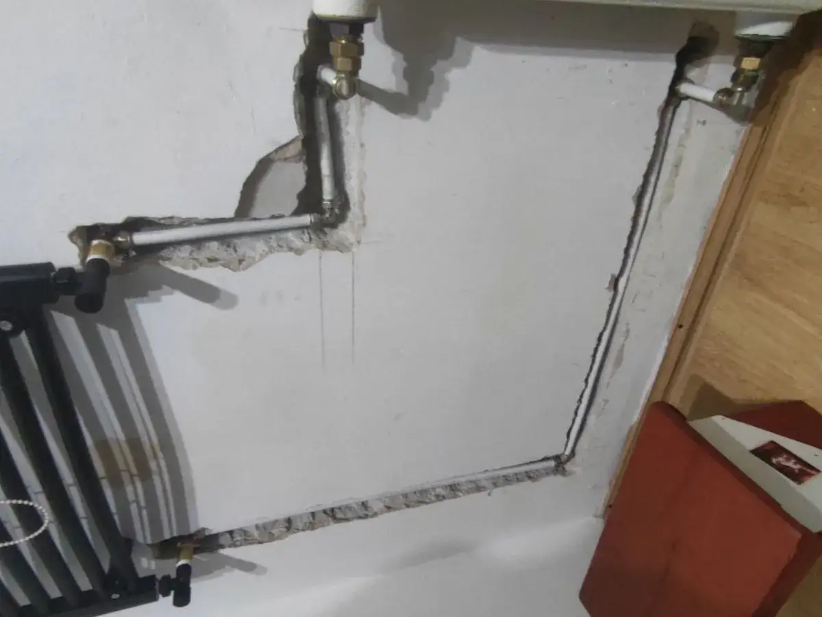 Instalacja hydrauliczna w ścianie, przygotowanie do podłączenia grzejnika łazienkowego do starej instalacji.
