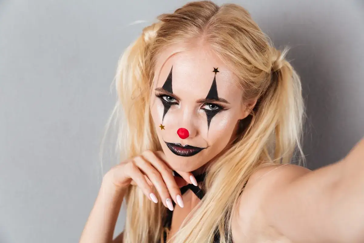 Ragazza con trucco da clown per Carnevale: un facile trucco da clown per ragazza semplice, con naso rosso, stelle e labbra nere.