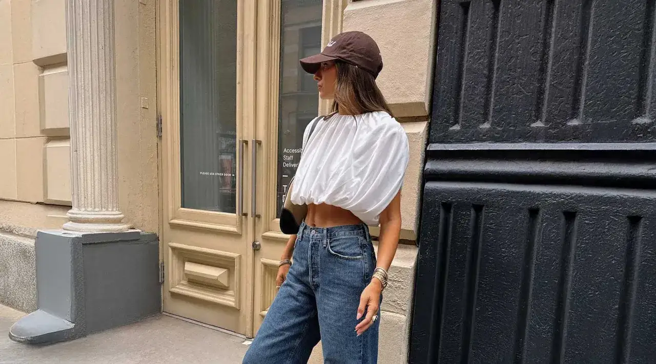 Frau mit brauner Cap richtig tragen, wei&szlig;es Crop-Top und Jeans.
