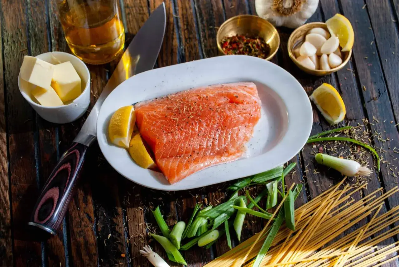 Filete de salmón crudo con limón, ajo, mantequilla y espaguetis, ingredientes para deliciosas recetas de salmón.