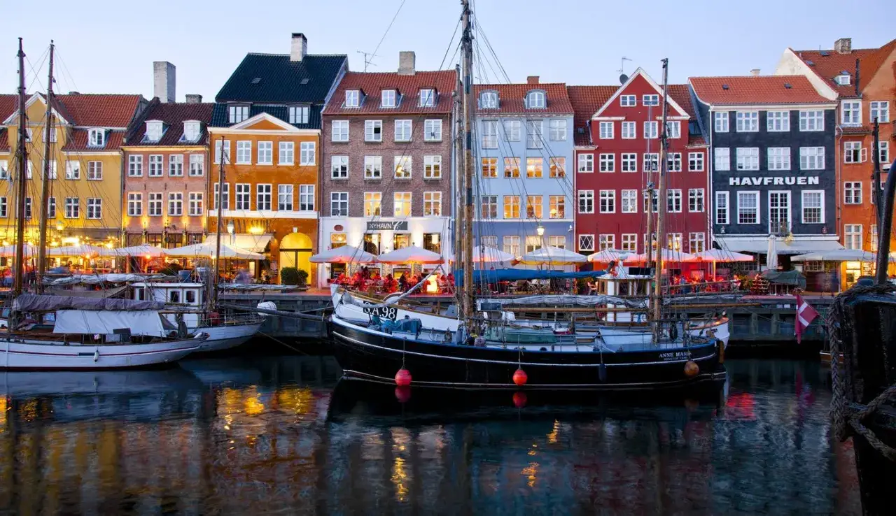 Bunte H&auml;user am Nyhavn, Kopenhagen must see. Boote im Wasser, Lichter spiegeln sich.