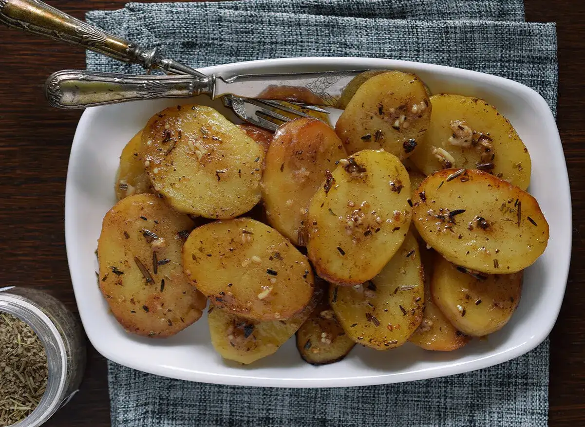 Patatas al horno doradas y jugosas, sazonadas con hierbas y ajo, listas para disfrutar.