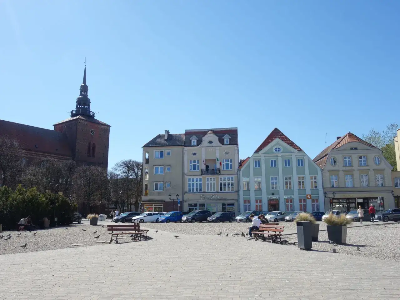 Słupsk atrakcje na weekend: Rynek z zabytkową wieżą kościelną, kolorowe kamienice i plac pełen gołębi.