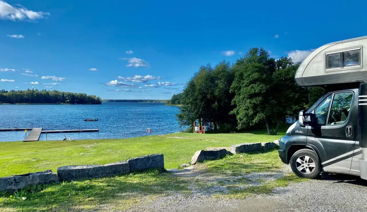 Husbil vid en sj&ouml; i Sverige en solig sommardag. Perfekt f&ouml;r en roadtrip sverige sommar.