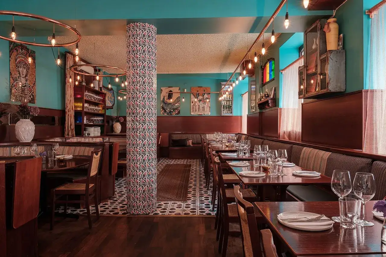 Mysig turkisk restaurang i Stockholm med vackert mönstrad pelare, träinredning och konst på väggarna.