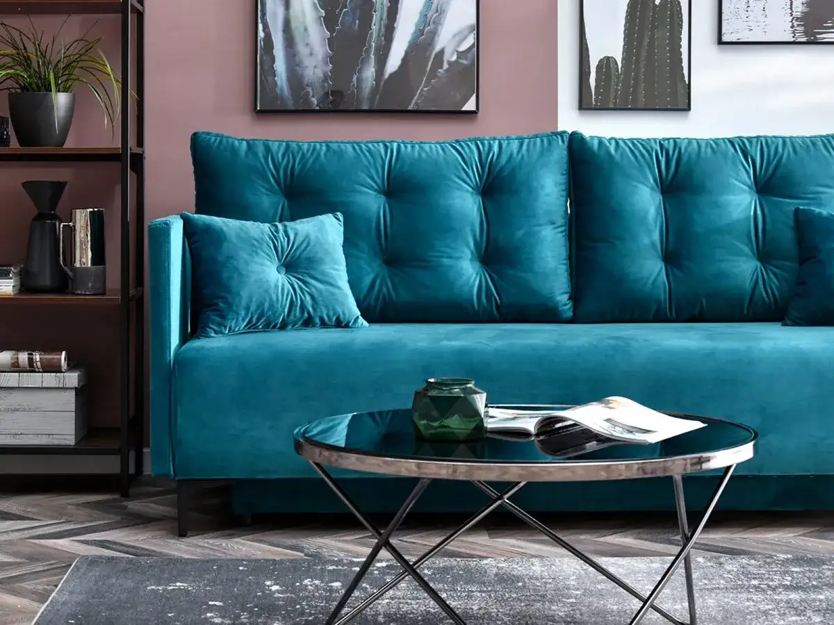 Nowoczesny zielony salon inspiracje: turkusowa sofa, czarna stolik kawowy, grafiki z kaktusami.