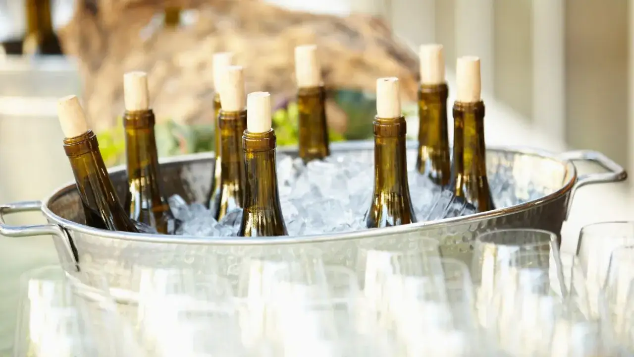 Mehrere Flaschen Champagner kühlen in einem Eisbad. Die perfekte Champagner Temperatur für den Genuss.