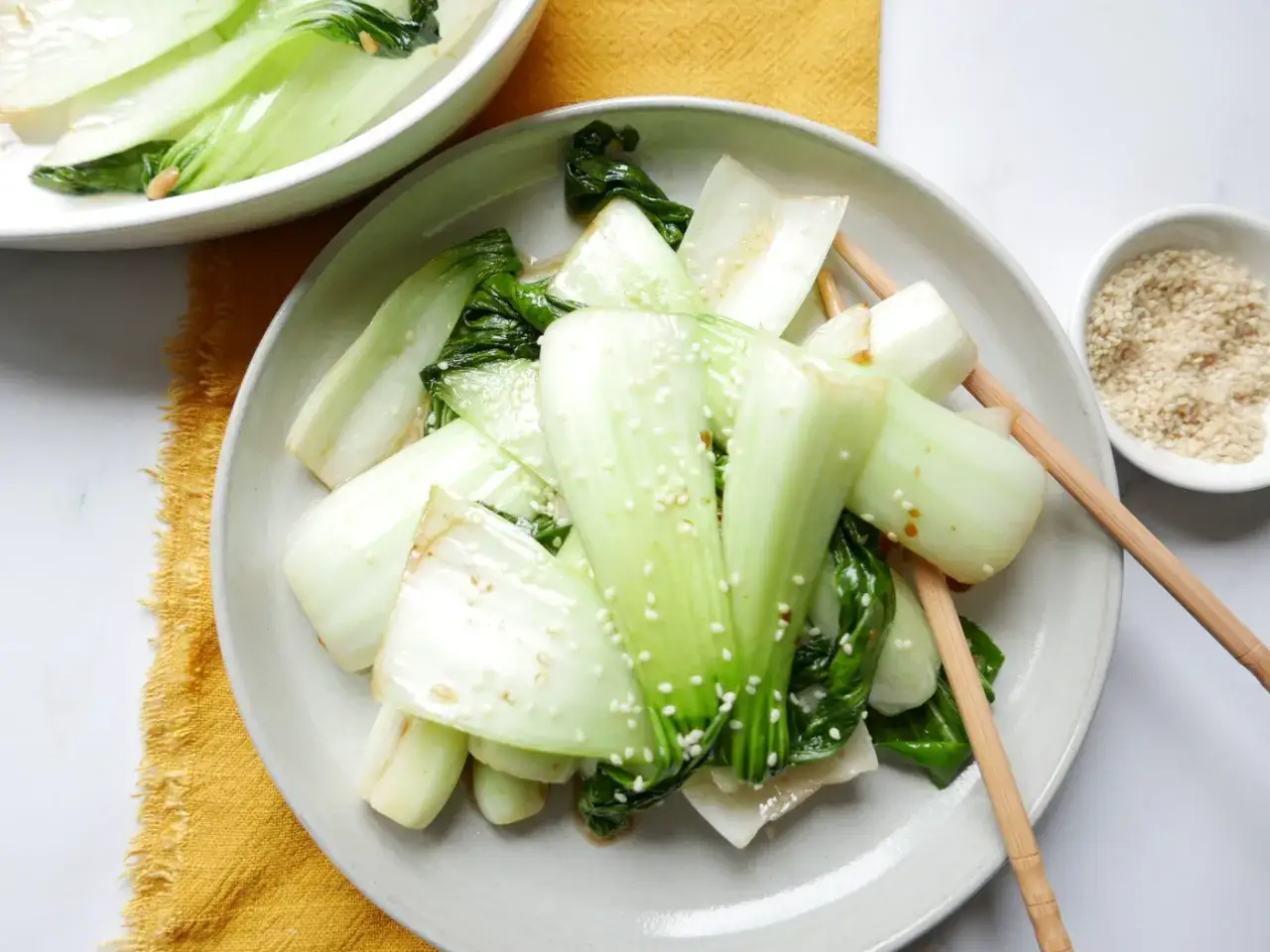 Pyszna, duszona salata pak choi posypana sezamem, gotowa do jedzenia pałeczkami.