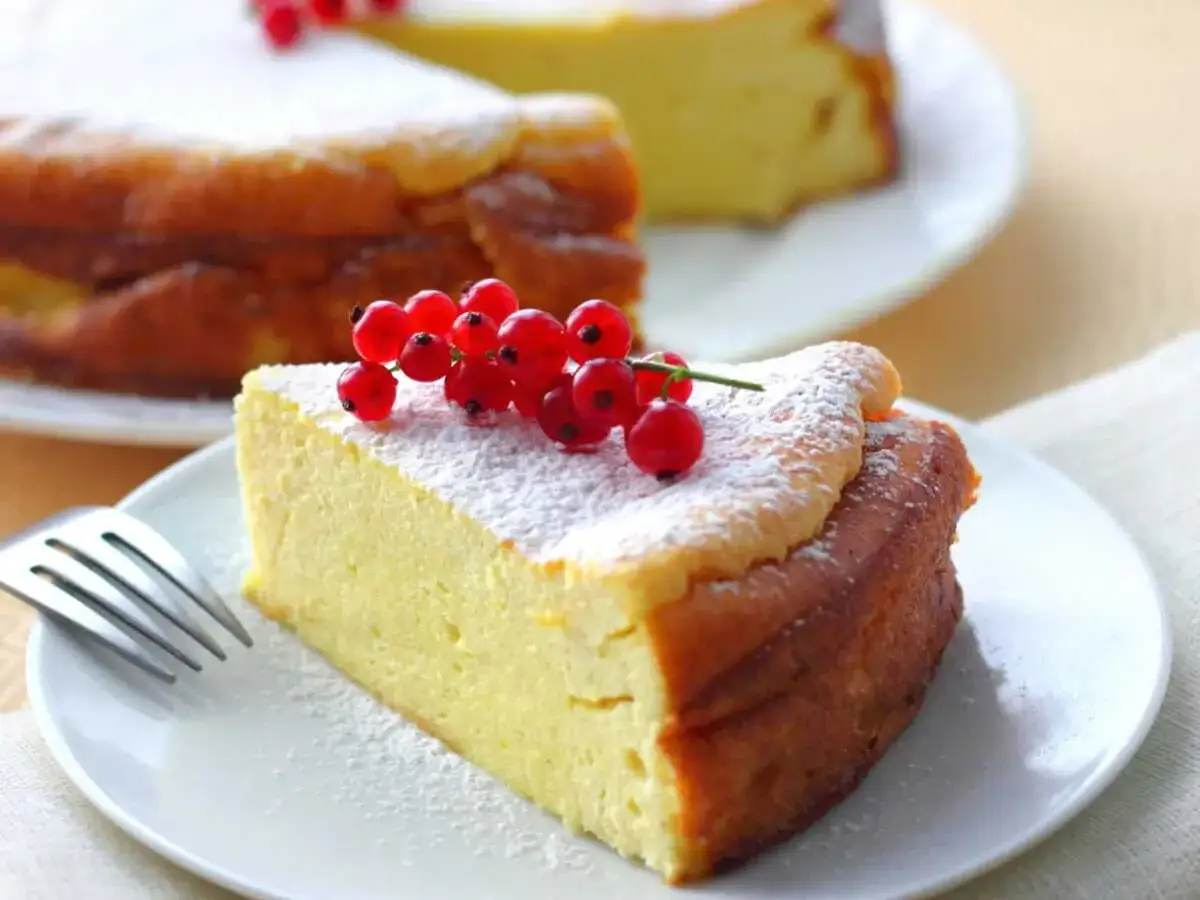 Tranche de gâteau léger à la ricotta, saupoudrée de sucre glace et garnie de groseilles. Un délice gourmand, mais attention aux calories de la ricotta !