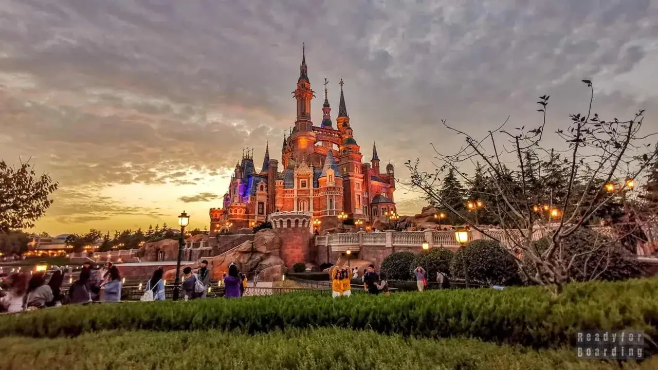 Bajkowy zamek w największym Disneylandzie na świecie, oświetlony o zmierzchu.
