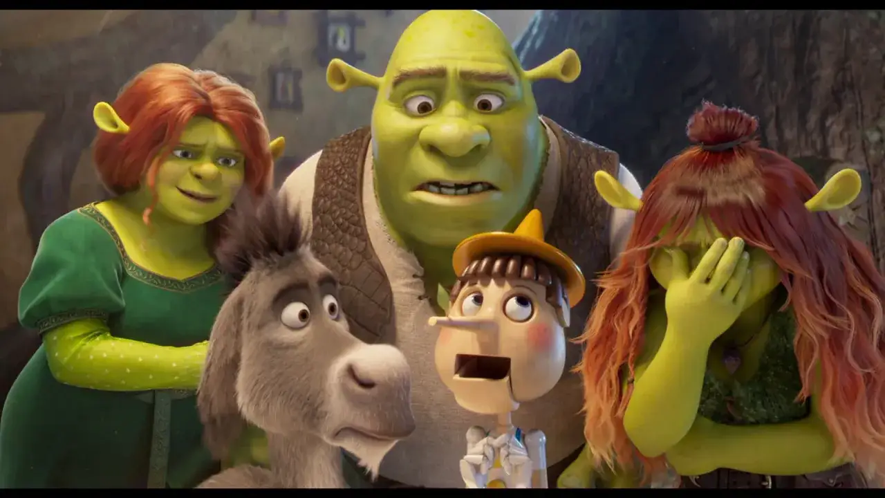 Shrek, Fiona, Osioł i Pinokio w zaskoczeniu. Jedna z postaci zasłania usta, jakby coś ją rozbawiło.