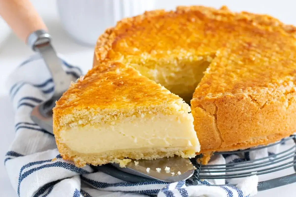 Un delicioso pastel vasco recién horneado, con una rebanada servida en un plato, listo para disfrutar.