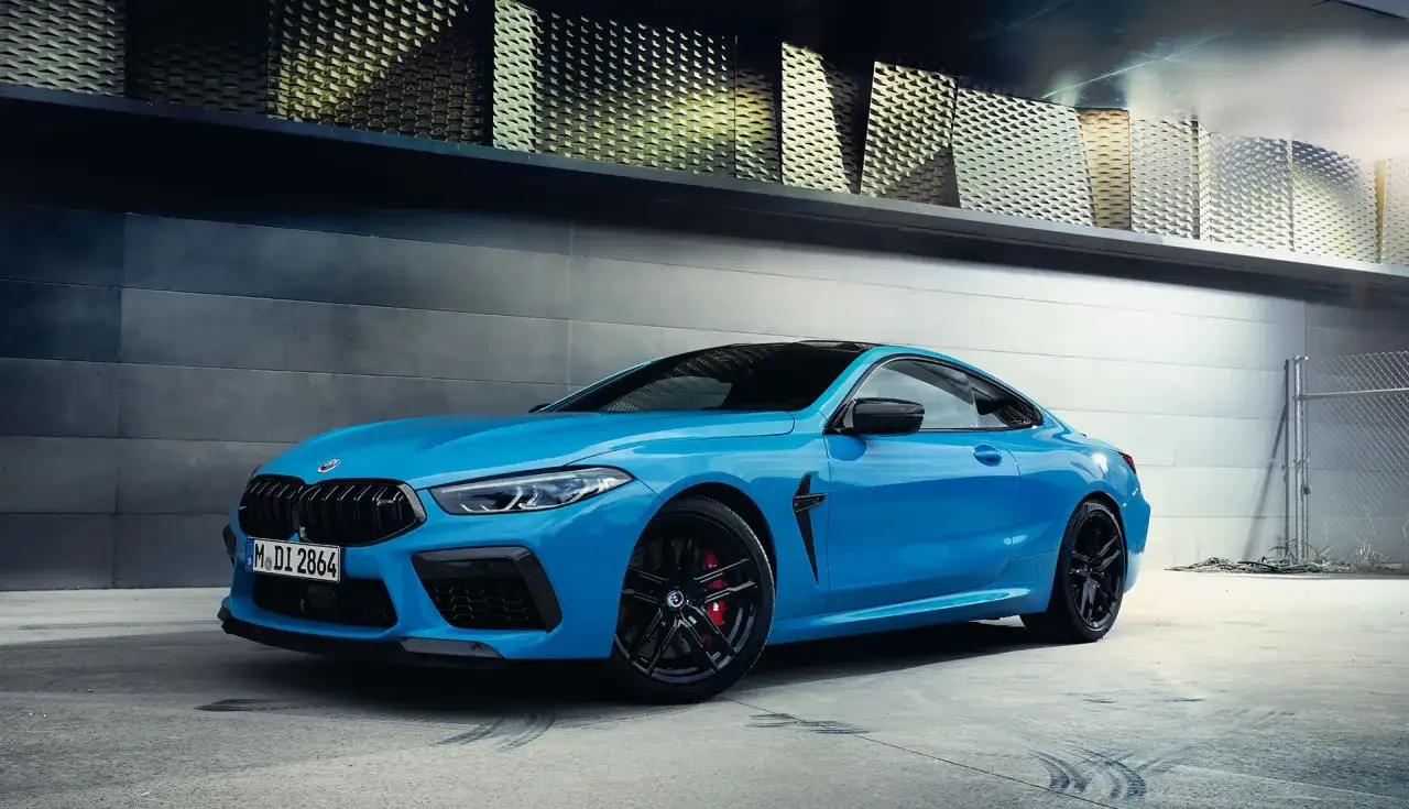 Niebieskie BMW M8 Competition z czarnymi felgami i czerwonymi zaciskami hamulcowymi. Sprawdź aktualną bmw m8 cena.