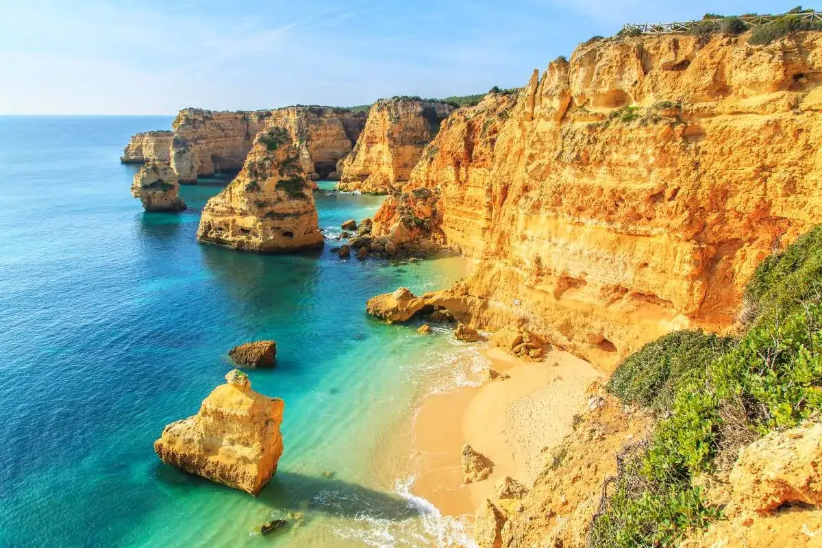 Felsformationen ragen aus dem t&uuml;rkisfarbenen Meer am Praia da Fal&eacute;sia. Die Stadt ist von beeindruckenden Klippen umgeben.