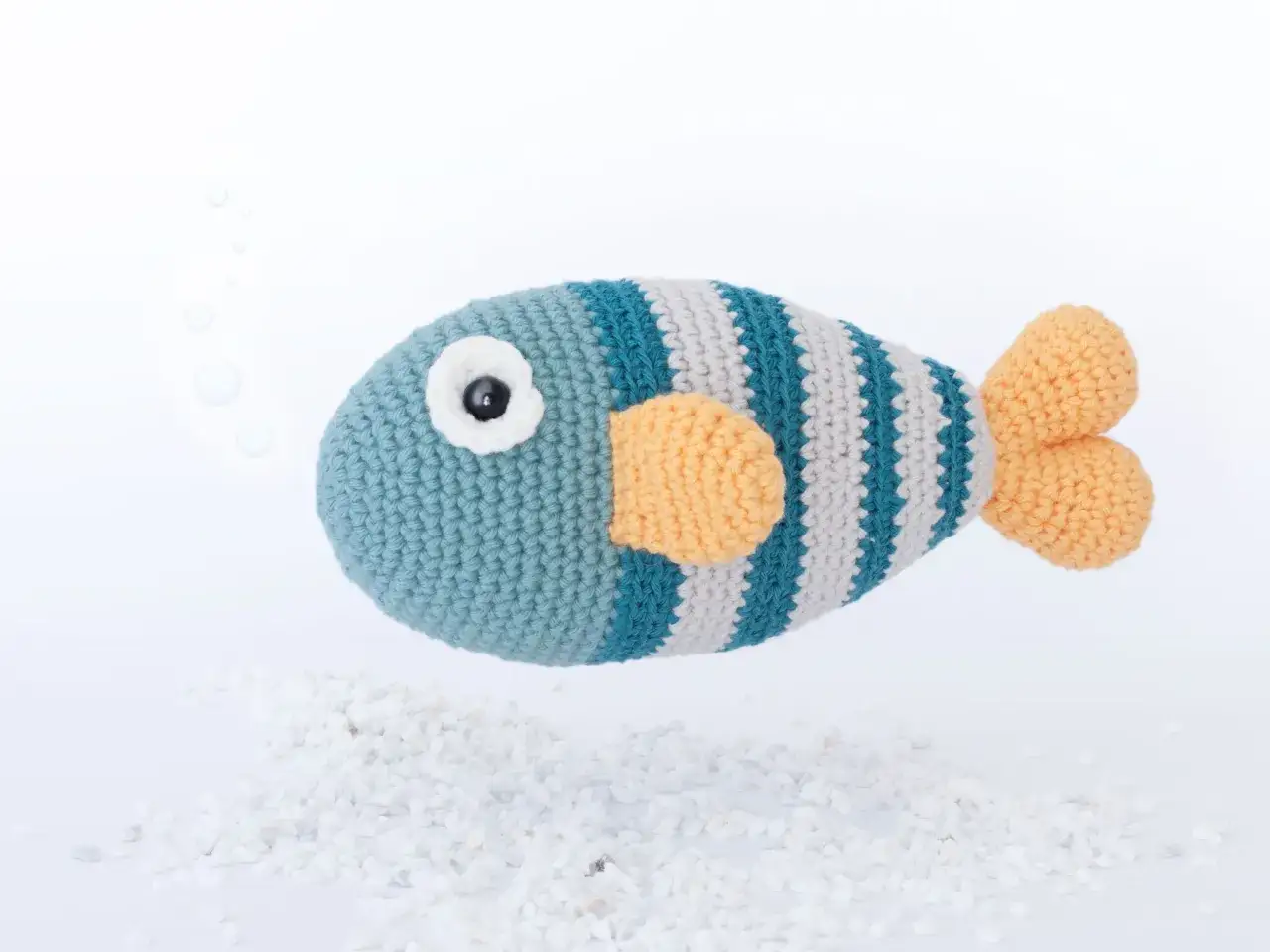 Pez de ganchillo a rayas azules y grises con aletas naranjas, ideal para patrones de peces de ganchillo.