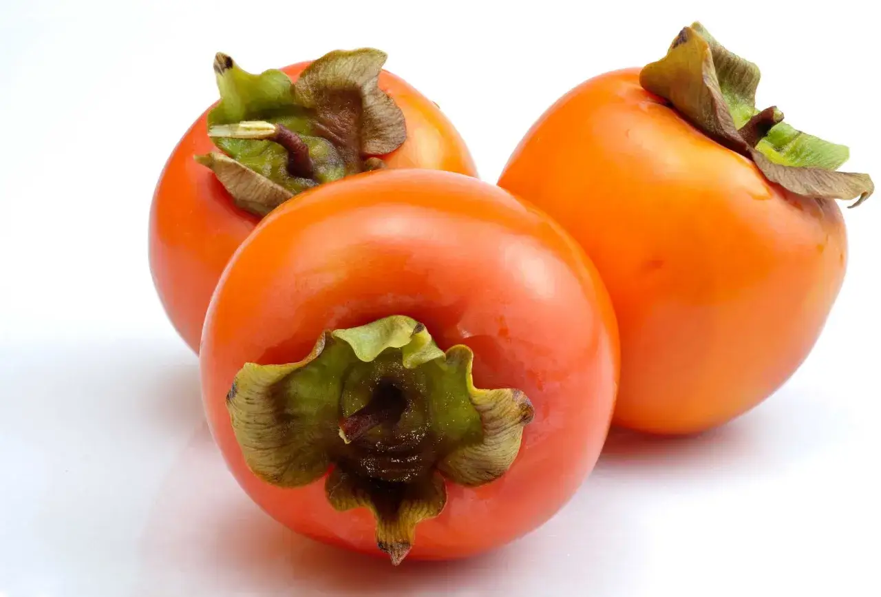 Tre cachi maturi e succosi, con la loro buccia arancione brillante. Chiss&agrave; quali cachi hanno i semi al loro interno, pronti per germogliare.