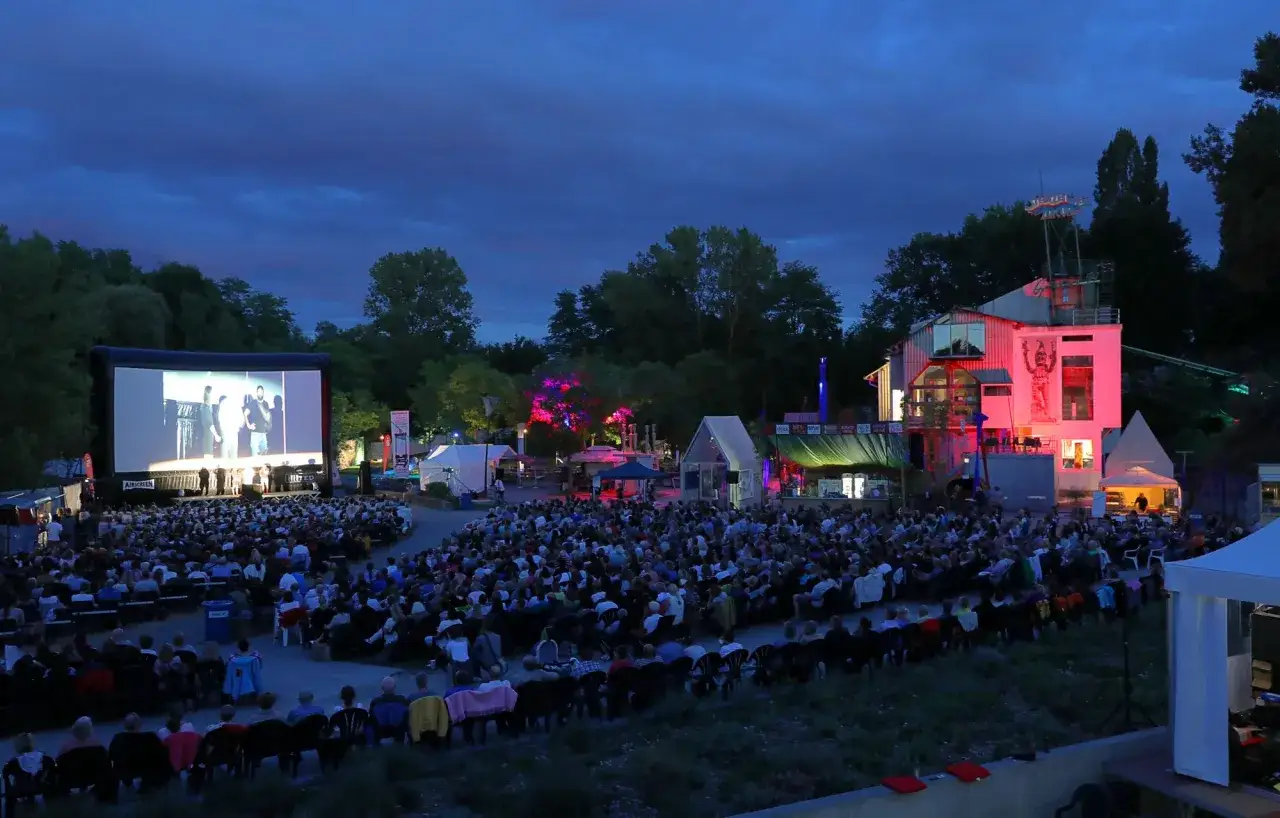 Gro&szlig;es Open-Air-Kino mit vielen Besuchern, weil der Stadt Veranstaltungen heute ein tolles Erlebnis bieten. Bunte Lichter und eine lebhafte Atmosph&auml;re.