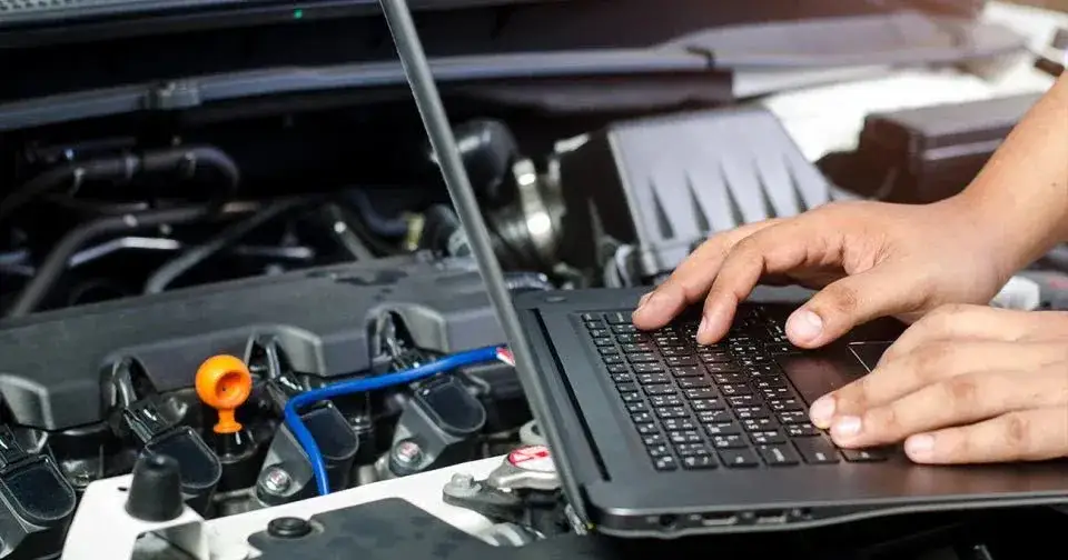 personne utilisant un ordinateur portable pour acheter des pièces détachées auto en ligne