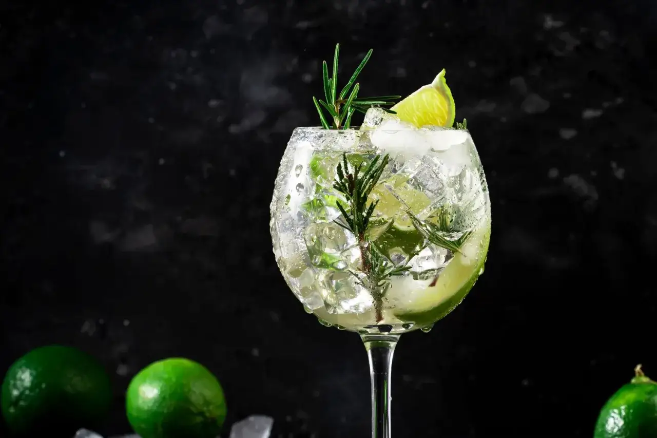 En svalkande gin och tonic med lime och rosmarin, perfekt för en varm sommardag.