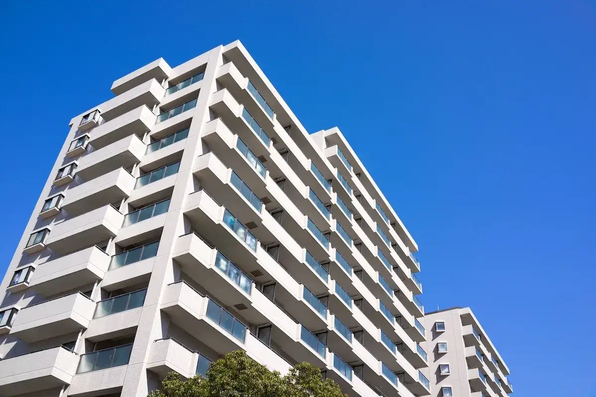 Edifici residenziali moderni sotto un cielo azzurro. Immagina il **stipendio portiere senza alloggio** per chi cura questi palazzi.