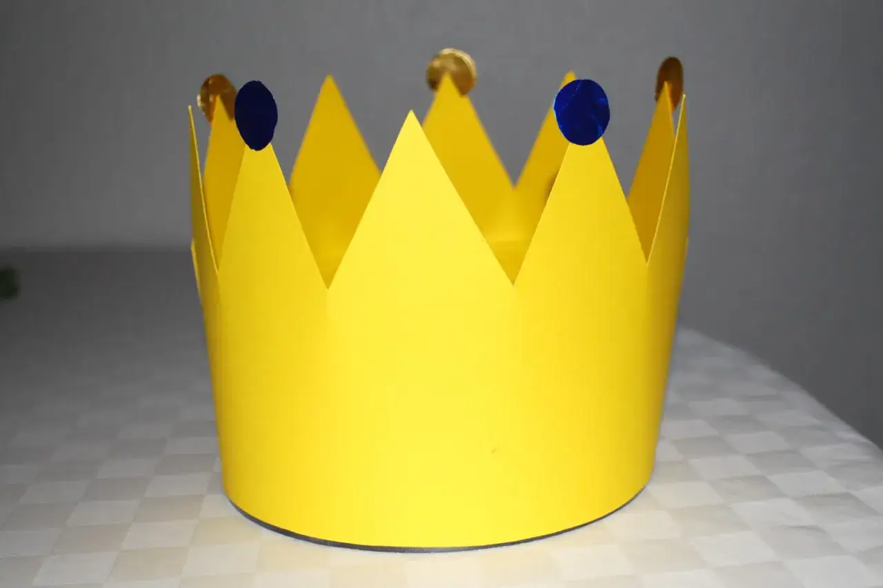 Gelbe Papierkrone, selbst gebastelt, mit blauen Tupfern und goldenen M&uuml;nzen verziert. Perfekt f&uuml;r kleine K&ouml;nige und K&ouml;niginnen.