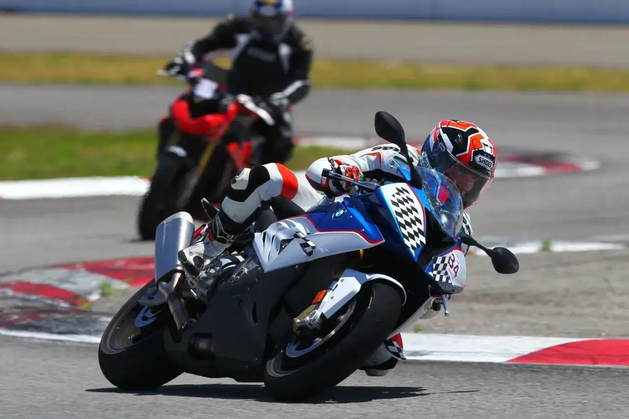 El piloto Davey Todd inclina su moto de carreras en una curva cerrada, con otro corredor detr&aacute;s.