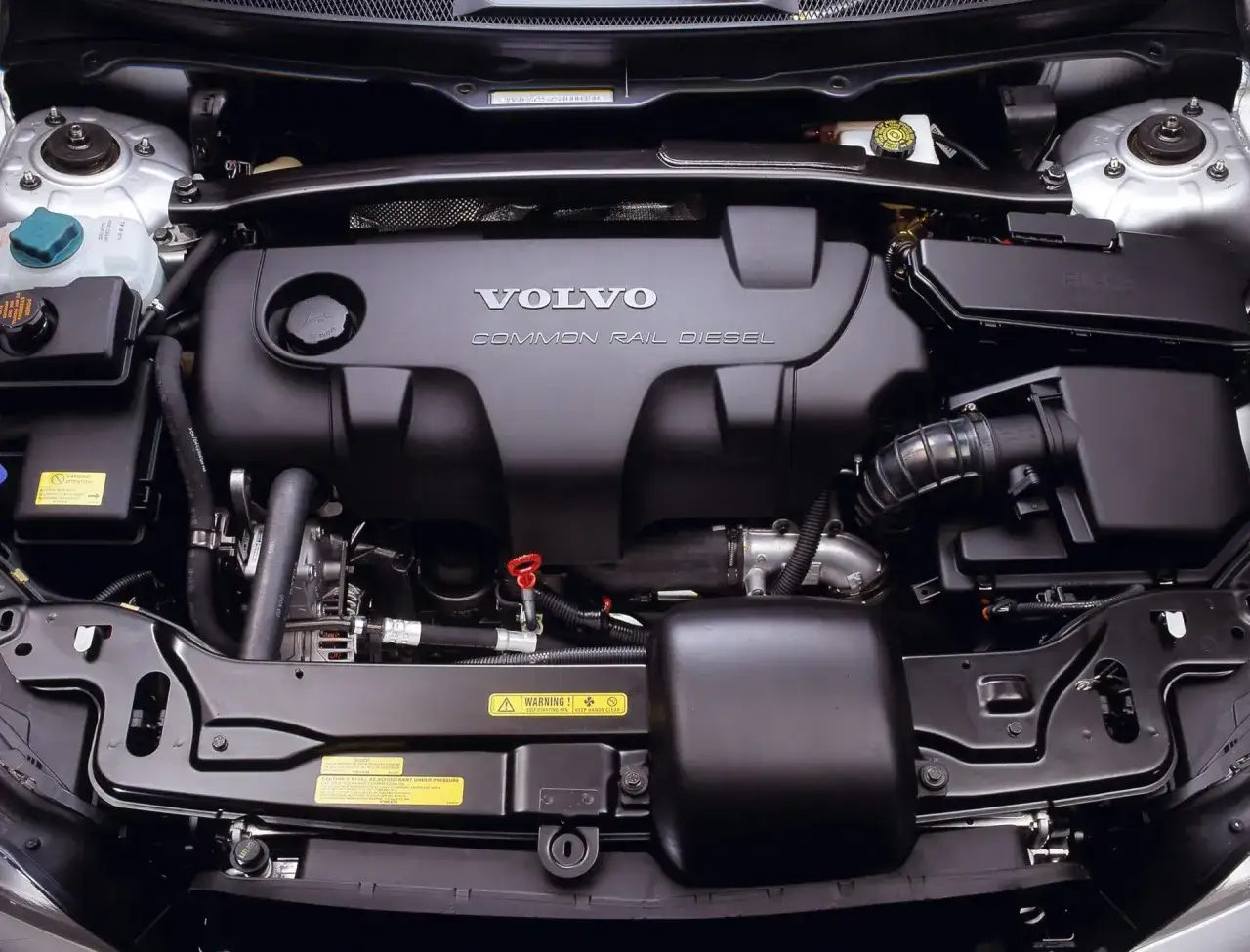 Silnik Volvo 2.4 D5 Common Rail Diesel. Widok z góry na czysty, zadbany silnik z widocznymi elementami układu dolotowego i osłonami.