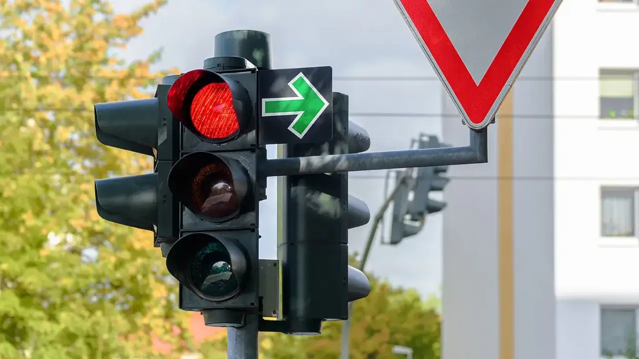 Ampel zeigt Rot, aber gr&uuml;ner Pfeil nach rechts erlaubt die Weiterfahrt. Die Reihenfolge der Verkehrsregelung ist hier klar: Der Pfeil hat Vorrang.