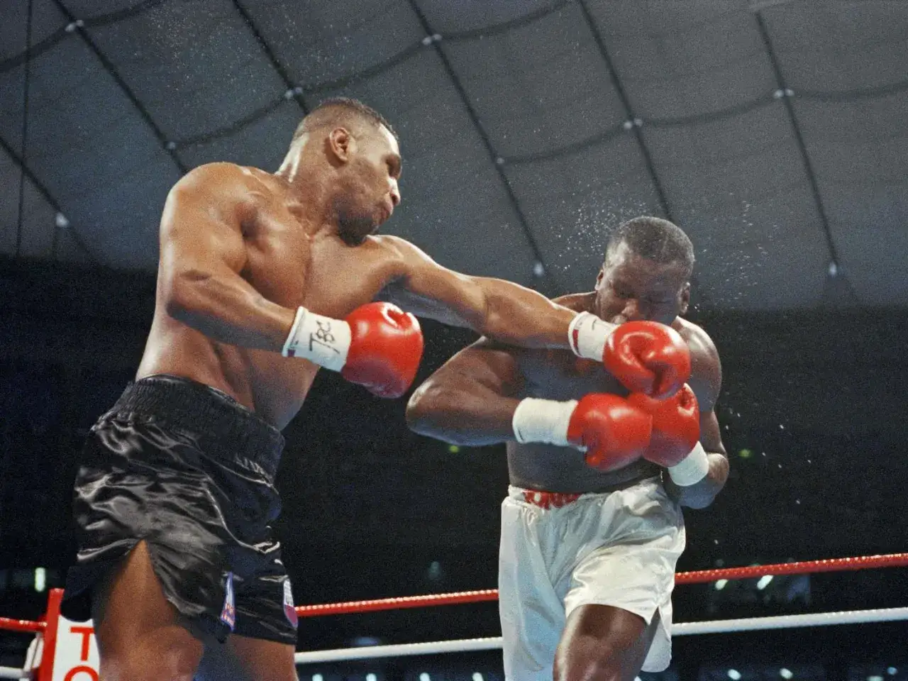 Mike Tyson lands a powerful punch, a moment captured from one of his best knockouts.