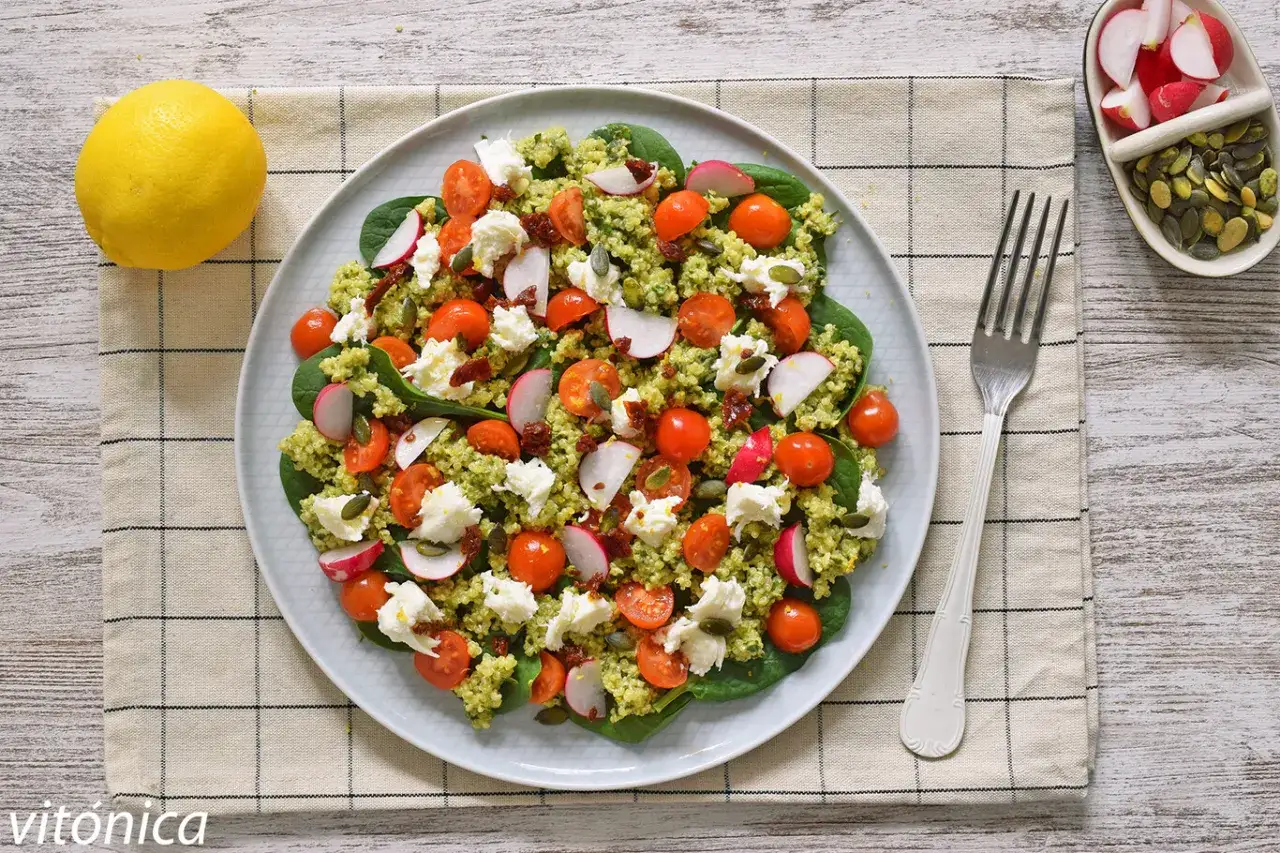 Deliciosa ensalada de quinoa para cenar, con tomates cherry, queso fresco, rabanitos y semillas.
