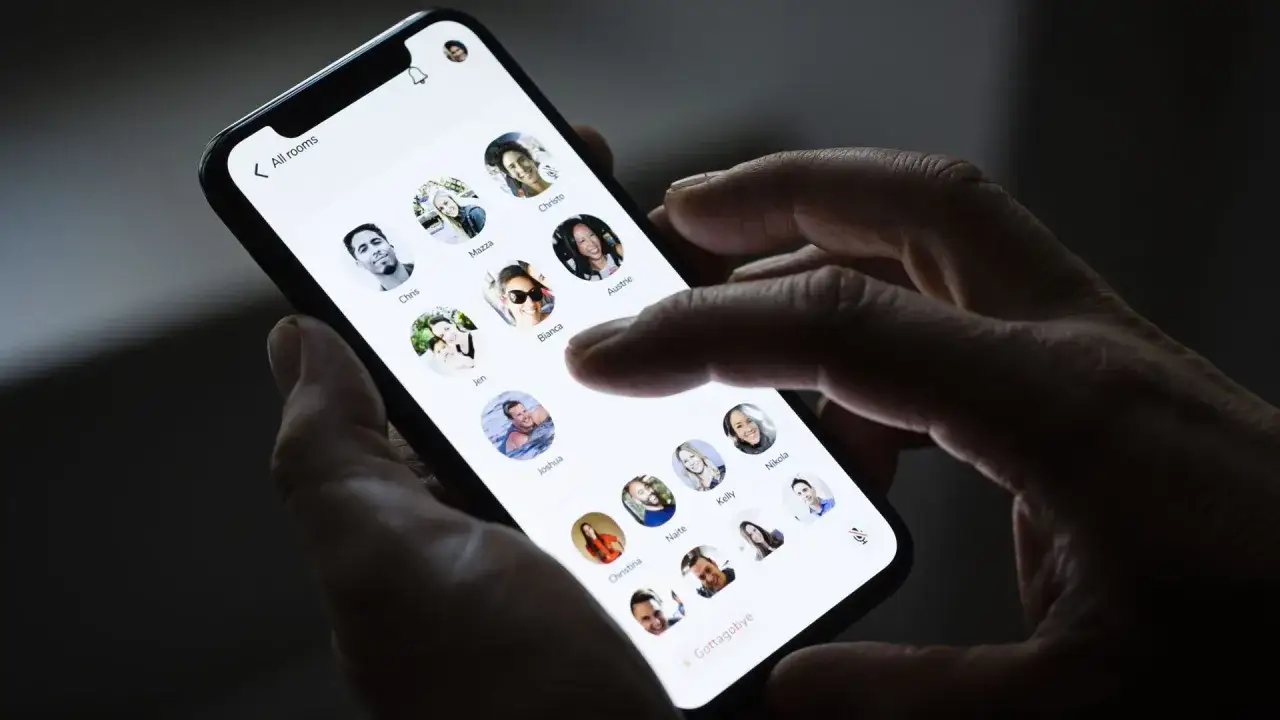 Dłoń trzyma smartfon z otwartą aplikacją **clubhouse**, wyświetlającą profile użytkowników.
