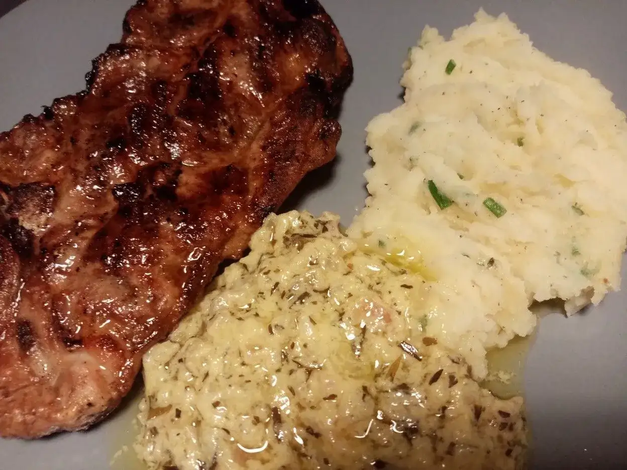 Steak grill&eacute; servi avec pur&eacute;e de pommes de terre et une onctueuse sauce &agrave; l'estragon pour viande.