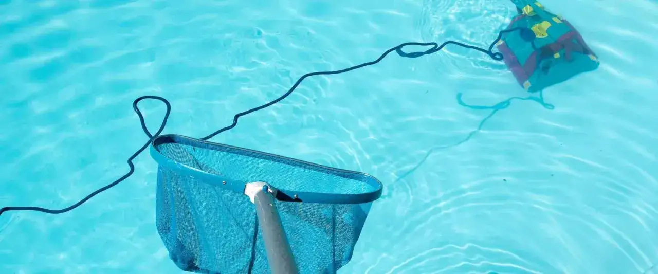 Red de piscina y limpiafondos autom&aacute;tico trabajando para reparar piscina.